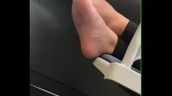 play College girl chilling in class, her feet bare, and propped up and relaxed on a chair next to her